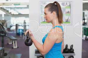 Fit brunette working out with kettlebell