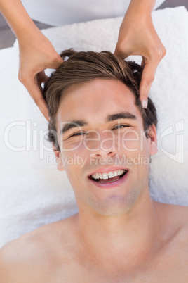 Man receiving head massage at spa center