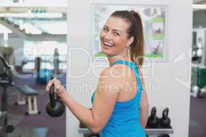 Fit brunette working out with kettlebell