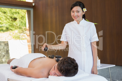 Man receiving stone massage at spa center