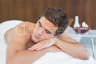 Man lying on massage table at spa center