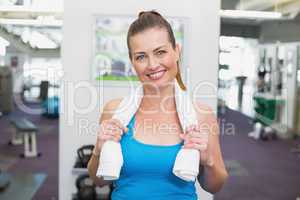 Fit brunette smiling at camera in fitness studio