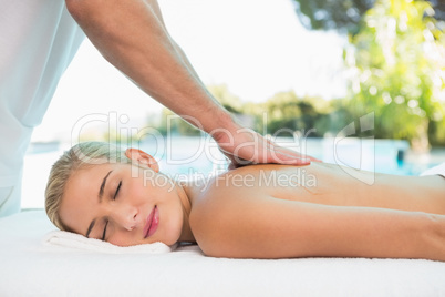 Woman receiving back massage at spa center