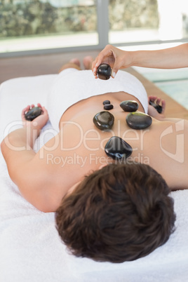 Man receiving stone massage at spa center