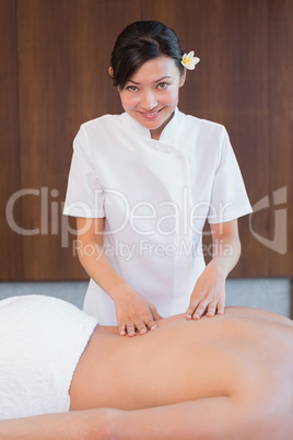 Female masseur massaging mans back at spa center