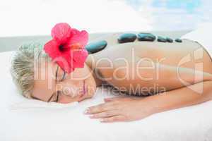 Beautiful woman receiving stone massage at health farm