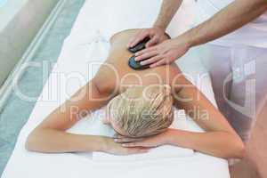 Woman receiving stone massage at health farm