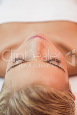 Beautiful woman lying on massage table at spa center