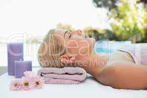 Beautiful woman lying on massage table at spa center