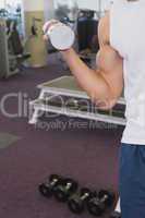 Fit man holding heavy dumbbell