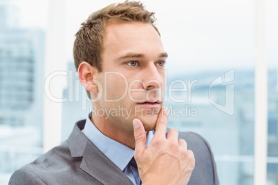 Thoughtful young businessman looking away