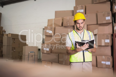 Worker with diary in warehouse