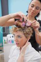 Hairdresser setting curlers in hair
