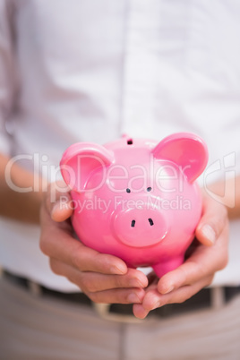 Mid section of man holding piggy bank