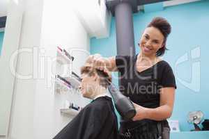 Hairdresser smiling and styling customers hair