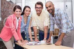 Business team standing and smiling at camera during meeting