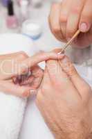 Manicurist cleaning a customers nails