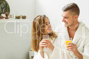 Couple drinking orange juice in bathrobes