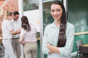 Smiling businesswoman standing with arms crossed