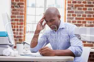 Casual businessman writing at his desk