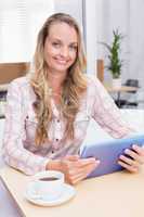 Smiling blonde businesswoman using her digital tablet