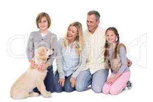 Family with their dog posing and smiling at camera together