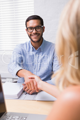 Businessman shaking hands with woman during interview