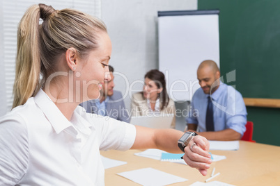 Businesswoman using her smart watch and smiling