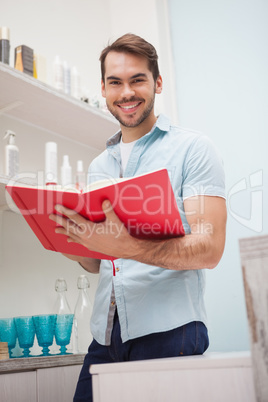 Smiling hairdresser with stock book