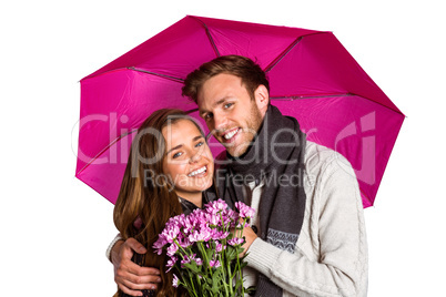 Cheerful young couple with flowers and umbrella