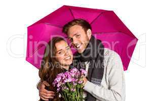 Cheerful young couple with flowers and umbrella