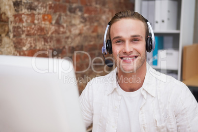 Man with headset typing on laptop