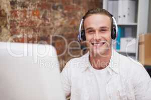 Man with headset typing on laptop