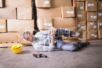 Worker lying on the floor in warehouse