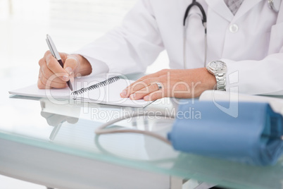 Doctor writing on a notepad