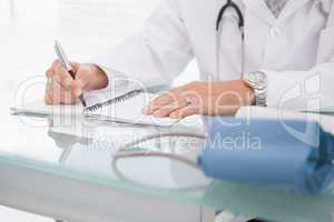 Doctor writing on a notepad