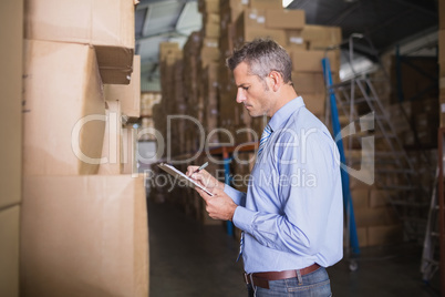 Manager holding clipboard in warehouse