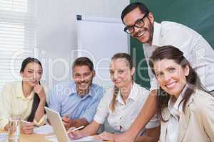 Casual business team having a meeting using laptop