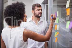 Casual business team looking at sticky notes