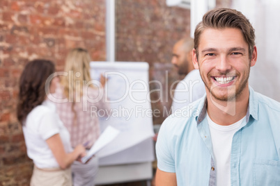 Casual businessman smiling at camera during meeting