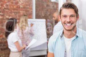 Casual businessman smiling at camera during meeting