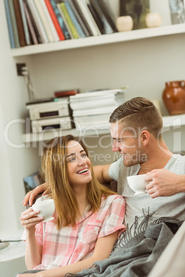 Cute couple relaxing on couch with coffee