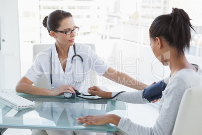 Doctor taking patients blood pressure