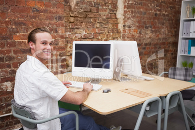 Creative worker typing on laptop at his desk