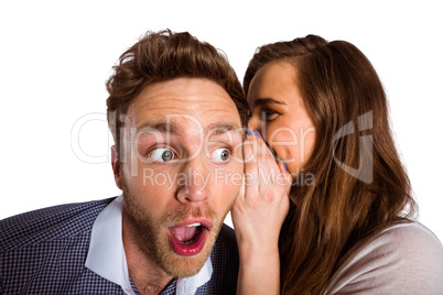 Woman whispering secret into friends ear