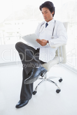 Focused doctor reading over notes