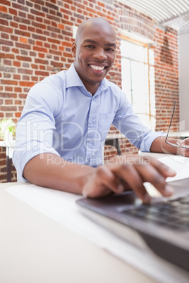 Casual businessman using his laptop at desk