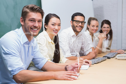Smiling business team sitting in a line