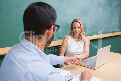 Businesswoman shaking hands with man during interview