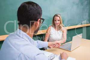 Businesswoman shaking hands with man during interview